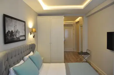 a living room with a bed and a television at Centrum Suites İstanbul in Istanbul