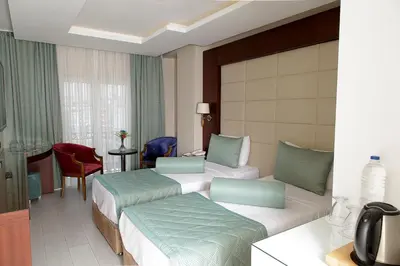 a hotel room with two beds and a table at Vatan Asur Hotel in Istanbul