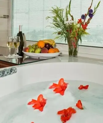a bath tub with a bowl of fruit and a bowl of flowers at Vatan Asur Hotel in Istanbul
