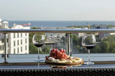 two glasses of wine and a plate of food on a balcony at Vatan Asur Hotel in Istanbul