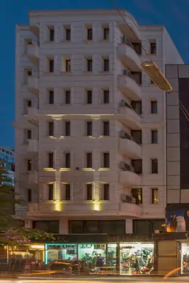 a tall white building with a lot of windows at Erbazlar Hotel in Istanbul