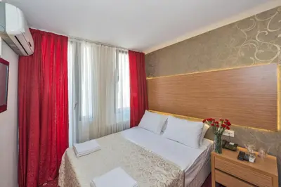 a hotel room with a bed and a window at Erbazlar Hotel in Istanbul