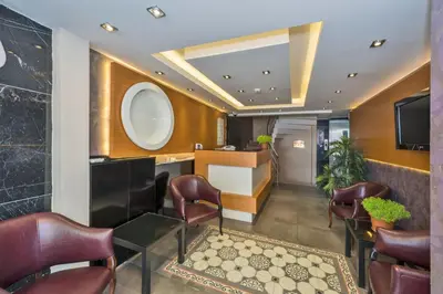 a lobby with a waiting room with chairs and a tv at Erbazlar Hotel in Istanbul
