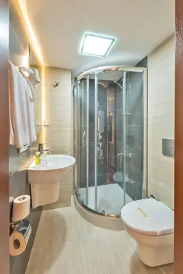 a bathroom with a shower and a toilet and a sink at Erbazlar Hotel in Istanbul