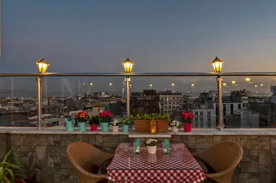 a table on a balcony with a view of a city at Erbazlar Hotel in Istanbul