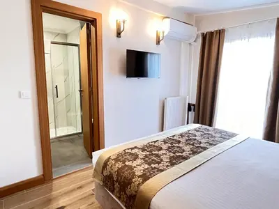 a bedroom with a bed and a television on the wall at Aren Suites in Istanbul