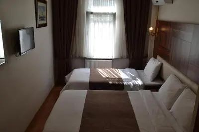 a hotel room with two beds and a window at Grand Fatih Hotel in Istanbul