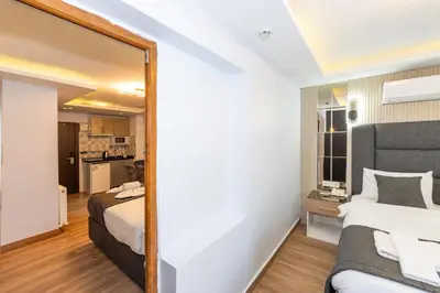 a mirror in a bedroom with a bed and a kitchen at T-Square Residence in Istanbul