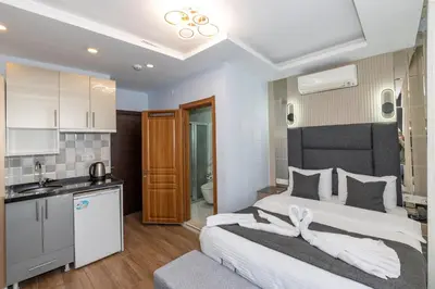 a bedroom with a large bed and a kitchen at T-Square Residence in Istanbul