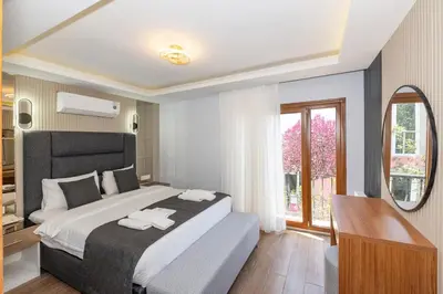 a bedroom with a large bed and a mirror at T-Square Residence in Istanbul