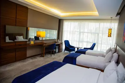 a hotel room with two beds and a desk at Gold Majesty Hotel in Bursa