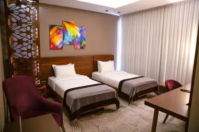 a hotel room with two beds and a table at Gold Majesty Hotel in Bursa