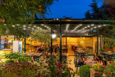 people sitting at tables in a restaurant at night at Olive Garden Apart in Istanbul