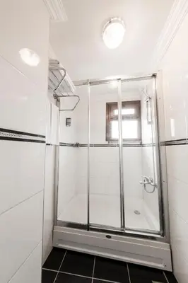 a shower with a glass door in a bathroom at Olive Garden Apart in Istanbul