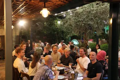 a group of people sitting at tables in a restaurant at Olive Garden Apart in Istanbul