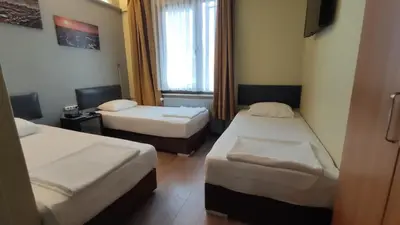 a hotel room with two beds and a window at Hotel Torun Istanbul Old City in Istanbul