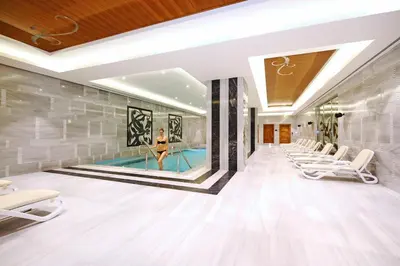 a pool hall with chairs and a woman in a swimming pool at Crowne Plaza Bursa Convention Center & Thermal Spa by IHG in Bursa