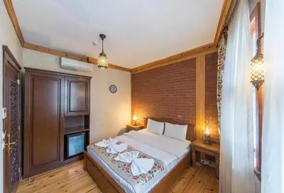 a bedroom with a bed and a brick wall at Lalinn Hotel in Istanbul