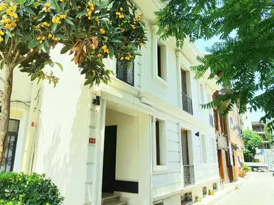 a white building with a tree in front of it at Lalinn Hotel in Istanbul