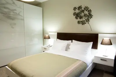 a bedroom with a bed with white sheets and two lamps at 116 Residence in Istanbul