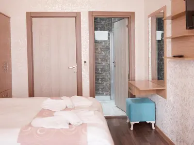 a bedroom with a bed and a desk and a mirror at HOTEL MİKLAGORD in Istanbul