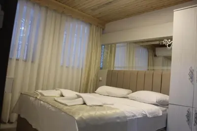 a bedroom with a bed with white sheets and a mirror at HOTEL MİKLAGORD in Istanbul
