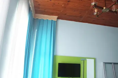 a room with blue curtains and a flat screen tv at HOTEL MİKLAGORD in Istanbul