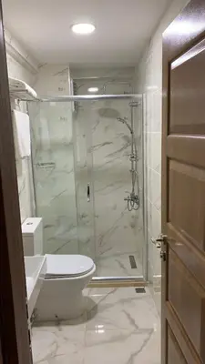 a bathroom with a toilet and a glass shower at Hotel Wiva in Istanbul
