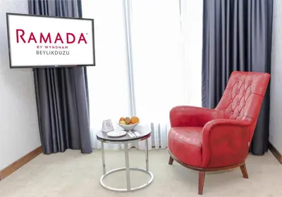 a red chair and a table in a room at Ramada by Wyndham Beylikduzu in Istanbul