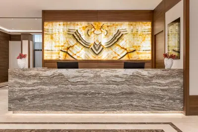 a lobby of a hotel with a marble reception desk at Ramada by Wyndham Beylikduzu in Istanbul