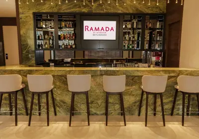 a bar at a restaurant with white stools at Ramada by Wyndham Beylikduzu in Istanbul