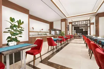 a restaurant with red chairs and tables and a bar at Ramada by Wyndham Beylikduzu in Istanbul