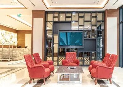 a lobby with red chairs and a tv at Ramada by Wyndham Beylikduzu in Istanbul