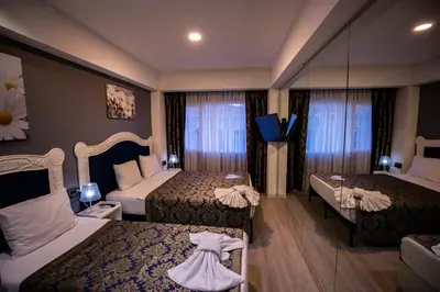 a hotel room with two beds with dresses on them at Albatros Hagia Sophia Hotel in Istanbul