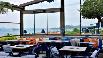 a restaurant with tables and chairs and a view of the ocean at Zimmer Bosphorus Hotel in Istanbul