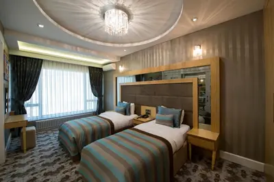a hotel room with two beds and a chandelier at The Berussa Hotel in Bursa