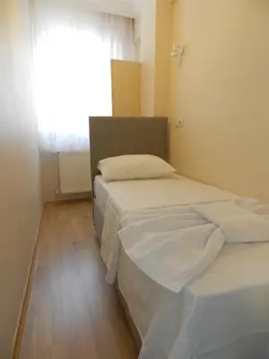 two beds in a small room with a window at Hagia Sophia Apartment in Istanbul