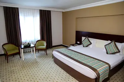 a hotel room with a bed and a table and chairs at Hotel Yayoba in Tekirdag