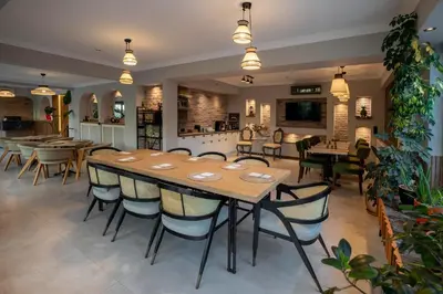 a restaurant with a large wooden table and chairs at Lagun Palas in Yalova