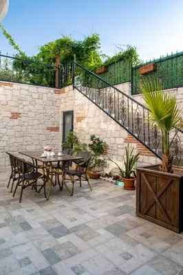 a patio with a table and chairs and a staircase at Lagun Palas in Yalova