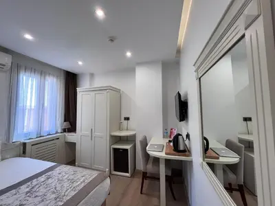a bedroom with a bed and a desk and a sink at Gul Hotel in Istanbul