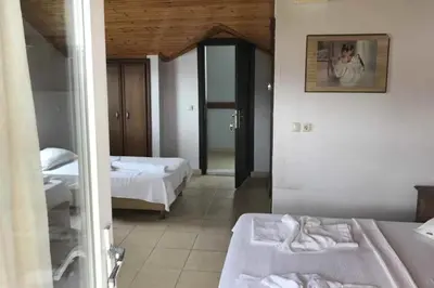 a hotel room with two beds and a mirror at Hotel Yasemin in Erdek