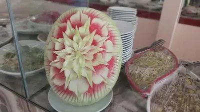 a cut up fruit in a bowl on a glass table at Hotel Yasemin in Erdek