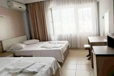 a hotel room with two beds and a window at Hotel Yasemin in Erdek