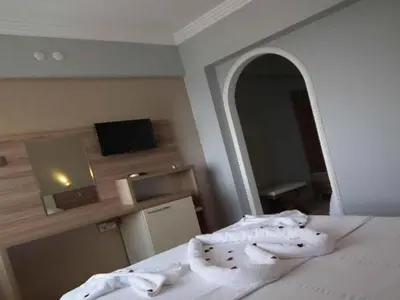 a bedroom with a bed with white towels on it at Hotel Yasemin in Erdek
