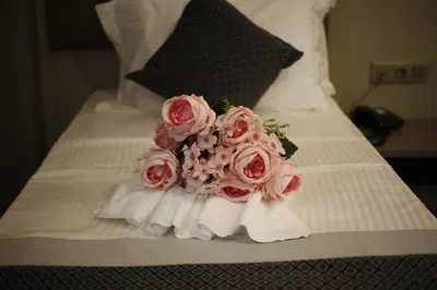 a bouquet of pink roses sitting on a bed at Anka Premium Hotel in Istanbul