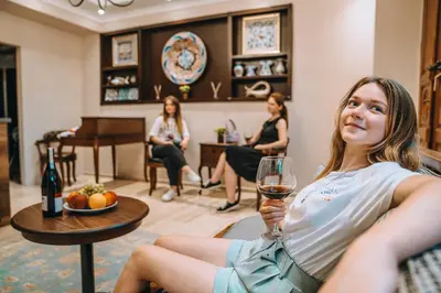 a woman sitting in a chair holding a glass of wine at Gulliver Mansion Hotel in Istanbul
