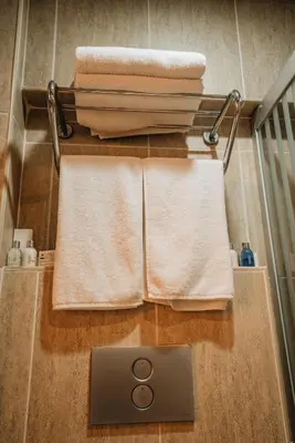 a bathroom with towels on a shelf and a sink at Gulliver Mansion Hotel in Istanbul