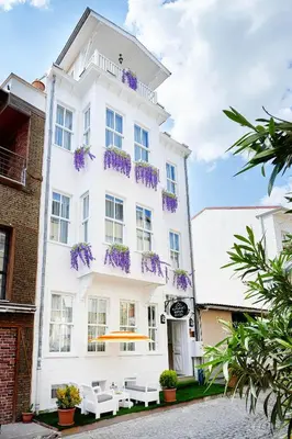 a white building with purple flowers on the balconies at Mataraci Konak in Istanbul