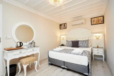 a bedroom with a bed and a vanity and a mirror at Mataraci Konak in Istanbul